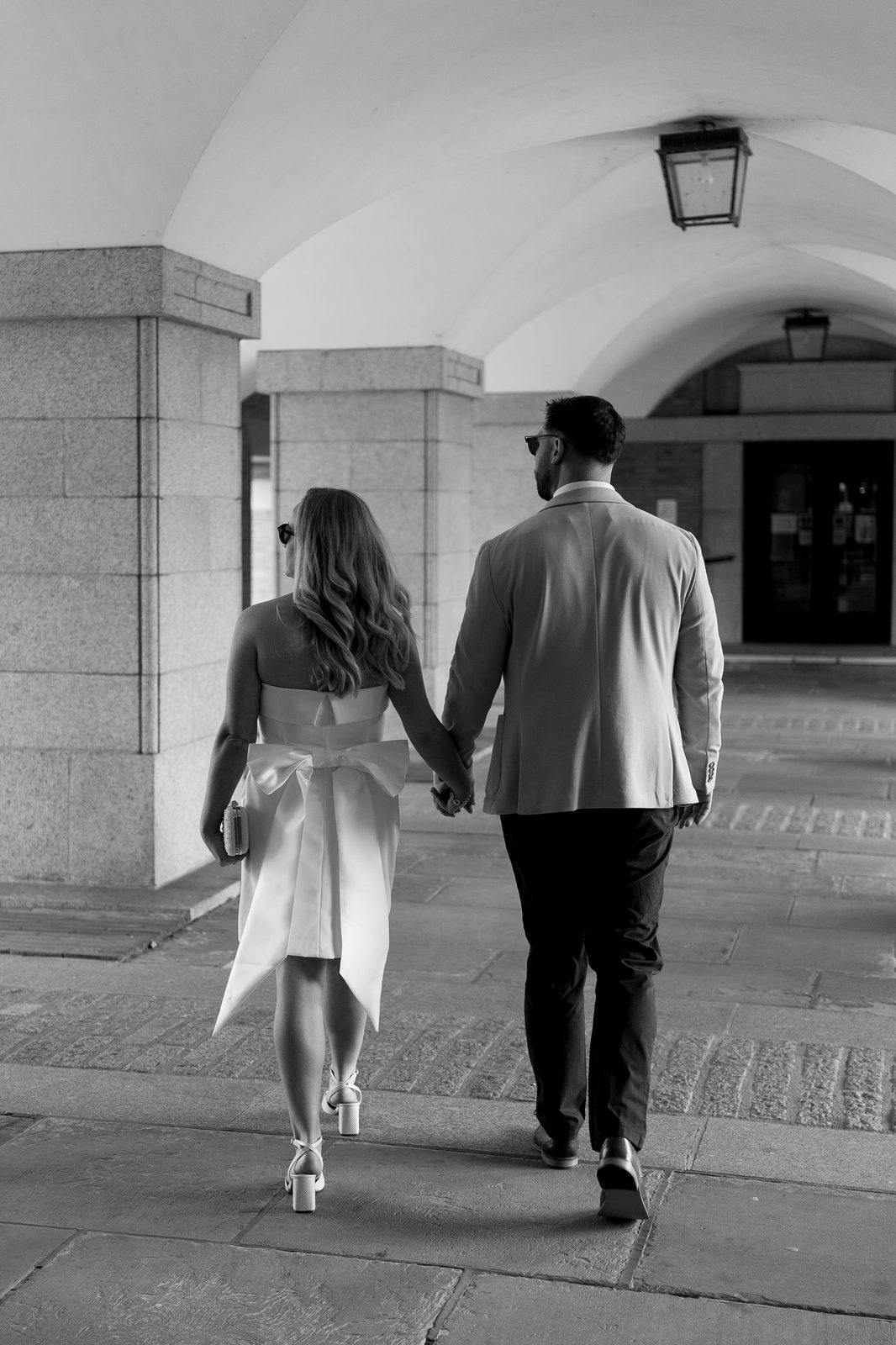 Couple walking hand in hand through an archway