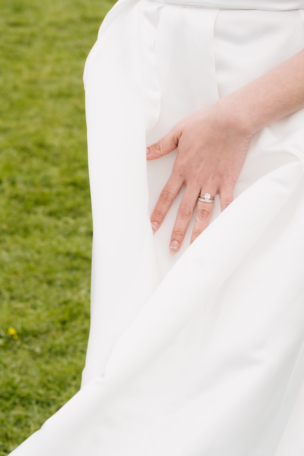 Bride's hand resting on her dress, ring detail
