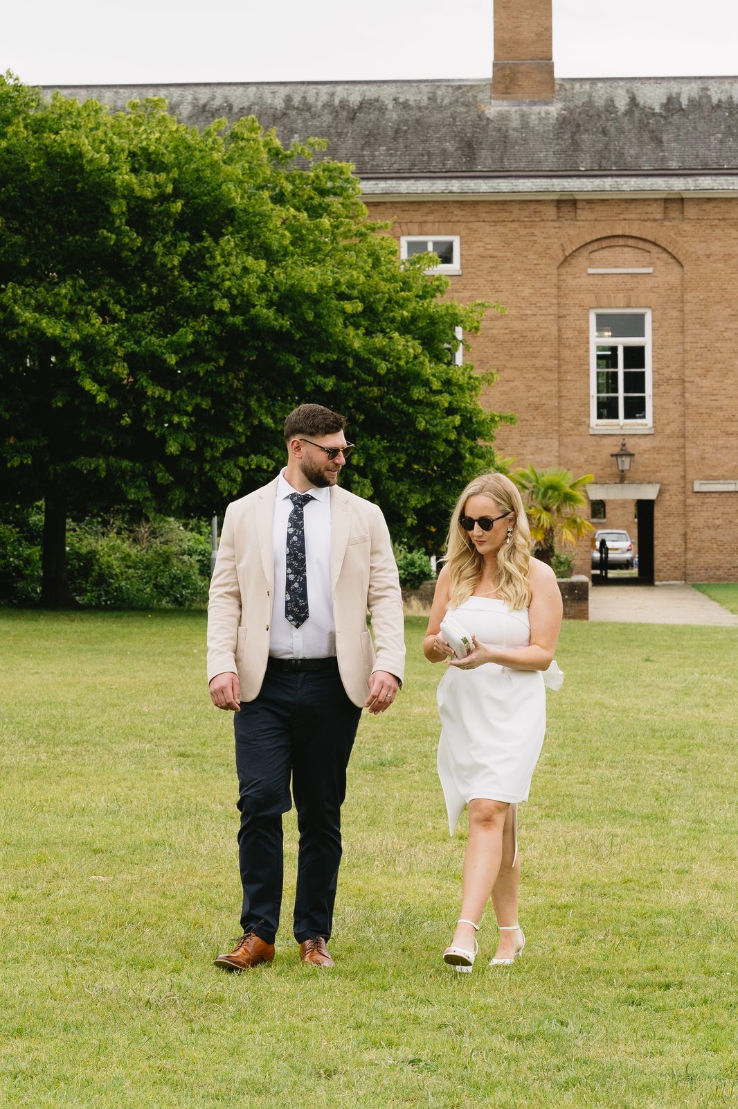 Couple walking across the lawn at their wedding