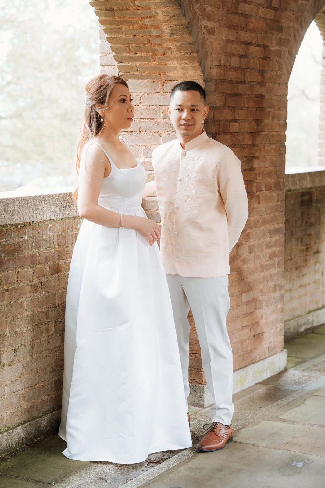Bride and groom portrait by a brick archway
