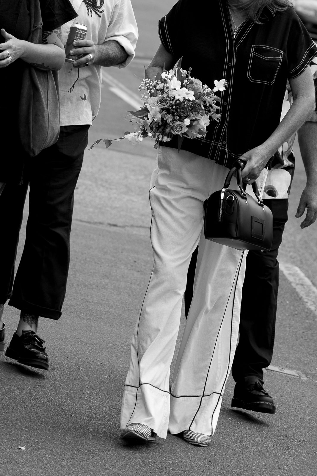 Guest carrying a bouquet, candid street moment